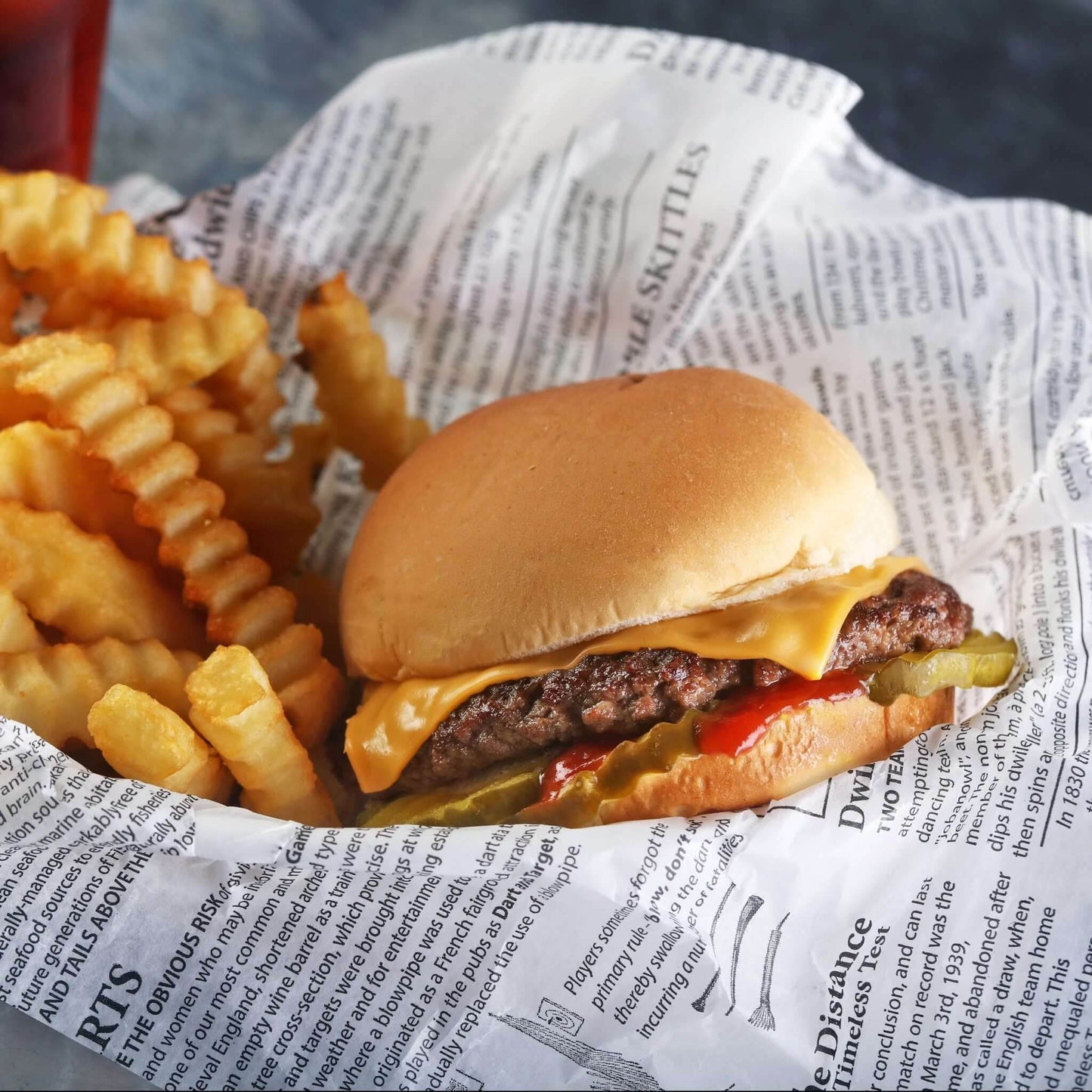 Hartie rezistenta la grasime model Ziar 30x40cm utilizata pentru ambalarea burgerilor si cartofilor prajiti.