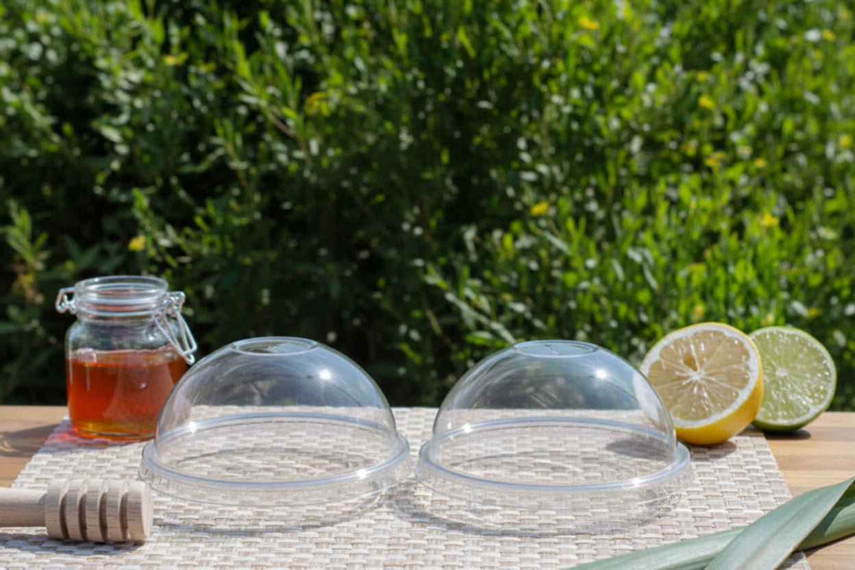 Capace pahare rPET 95mm bombat fara gaura pe pahare cu ceai rece, decorate cu felii de lamaie.